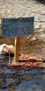 Moradores do Pontal colocaram um placa para sinalizar os buracos na rua.